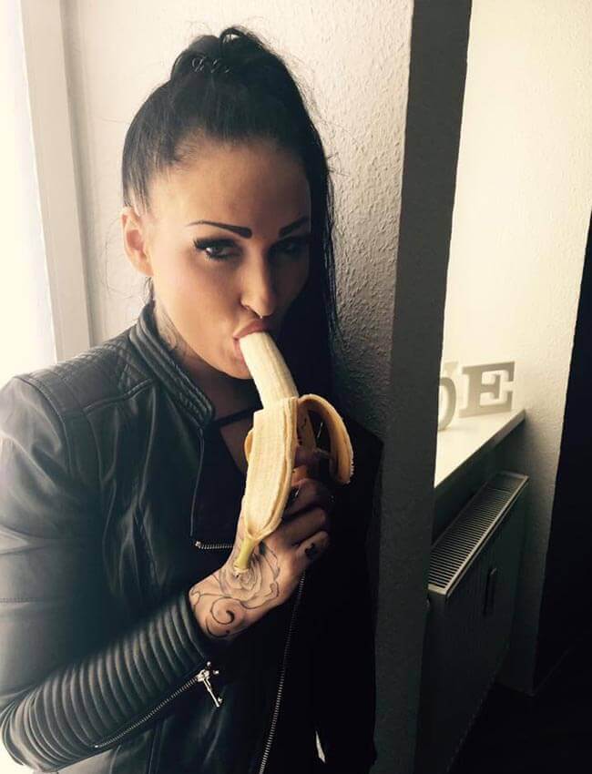 Mira Grey mit Leder-Jacke bläst eine Banane