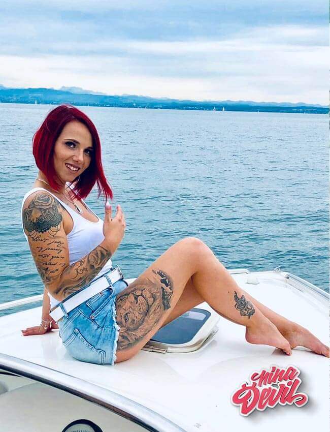 Nina Devil auf einem Boot mit weißem Top und kurzer Jeans